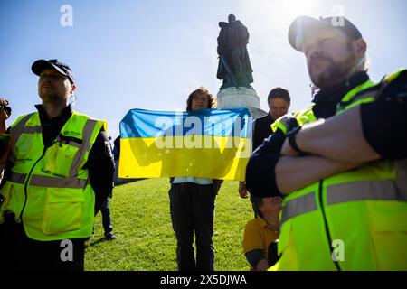 Berlin, Germany. 09th May, 2024. A man with a Ukrainian flag is surrounded by police officers at the Soviet memorial in Treptower Park. May 8 and 9 marks the 79th anniversary of the liberation from National Socialism. Credit: Christoph Soeder/dpa/Alamy Live News Stock Photo