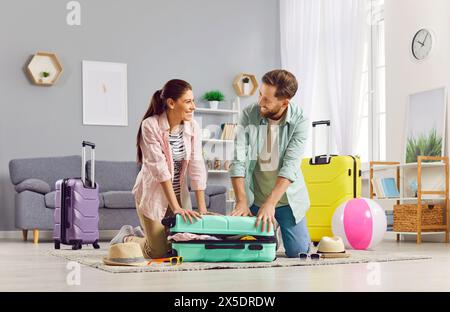 Couple Packing Suitcase For Summer Vacation Stock Photo