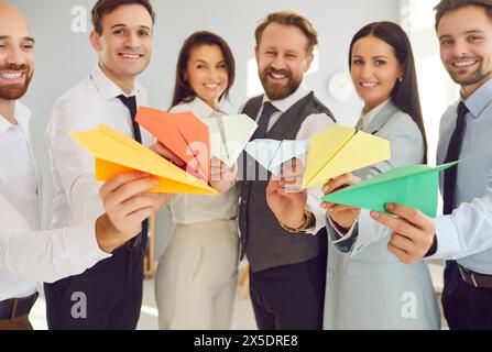Group Of Office Workers Holding Colorful Paper Airplanes Stock Photo