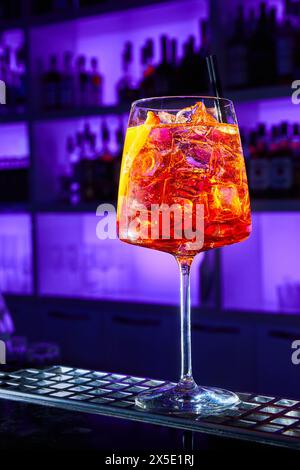 Alcoholic cocktail with ice and a piece of orange on the bar counter Stock Photo