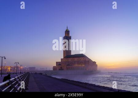 Blue hour (after sunset) view of the Hassan II Mosque, with the promenade and El Hank Lighthouse, in Casablanca, Morocco Stock Photo