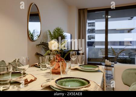 Dining table in a living room with glassware and cutlery prepared. Stock Photo