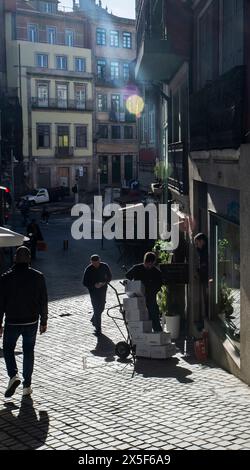 Oporto, Portugal - November 23, 2023: Delivery man with a forklift with boxes on a street in Oporto, Portugal Stock Photo