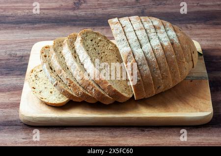 Loaf of multigrain bread on a wood tray Stock Photo