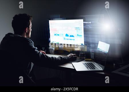 Computer screen, hacking and man with programming overlay for firewall, password and cybersecurity. Software, data analysis and hacker with coding Stock Photo