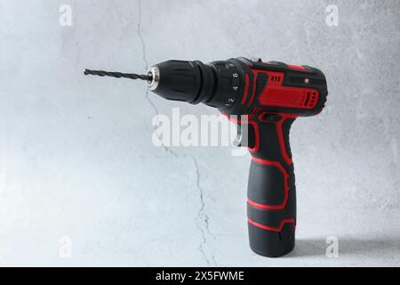 Modern cordless electric screwdriver on light table Stock Photo
