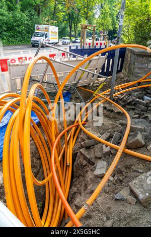 Laying of fiber optic cables, empty conduits are laid under a sidewalk, in which the actual fiber optic cable is later blown in and connected to the r Stock Photo