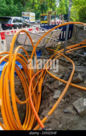 Laying of fiber optic cables, empty conduits are laid under a sidewalk, in which the actual fiber optic cable is later blown in and connected to the r Stock Photo