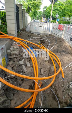 Laying of fiber optic cables, empty conduits are laid under a sidewalk, in which the actual fiber optic cable is later blown in and connected to the r Stock Photo
