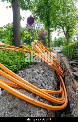 Laying of fiber optic cables, empty conduits are laid under a sidewalk, in which the actual fiber optic cable is later blown in and connected to the r Stock Photo