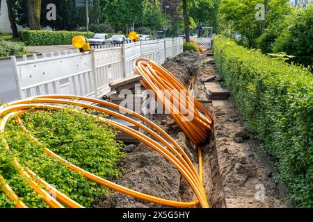Laying of fiber optic cables, empty conduits are laid under a sidewalk, in which the actual fiber optic cable is later blown in and connected to the r Stock Photo