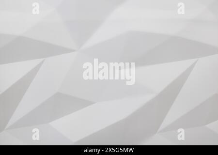 3D white geometric background. Seamless texture, triangles of different shapes. The concept of a modern interior made of plaster moulding. Stock Photo