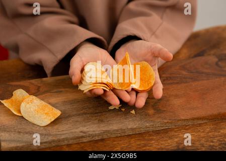A close view of a hand picking a chip from a spread of chips on a table. Stock Photo