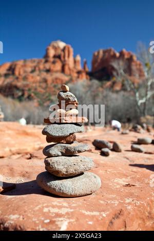 Balanced rocks constructed on Buddah Beach in Sedona's Oak Creek Canyon with Cathedral Rock in the background. This area is one of Sedona's Psychic Vo Stock Photo