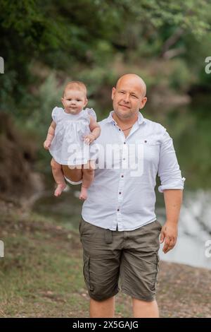 dad holds a baby in his arms in the summer. High quality photo Stock Photo