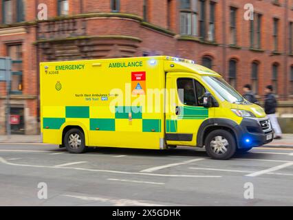 North West Ambulance service emergency ambulance responding to a call at speed in panning shot in manchester  NHS Stock Photo