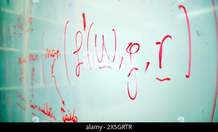 Mathematical formula and notes written in red marker on a whiteboard, depicting the complexity and dynamic nature of academic research and science Stock Photo