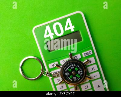 Top view compass and calculator with number 404 on green background. Stock Photo