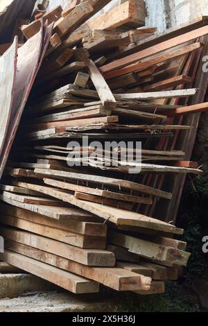 pile of old waste wood planks from construction or demolition site, stack of trash wood with nails splinters, close-up garbage heap in selective focus Stock Photo