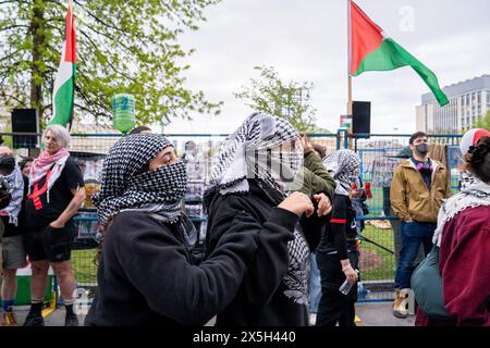 Toronto, Canada. 08th May, 2024. Two Pro-Palestinian students wearing keffiyehs walk side by side during the demonstration. Pro-Palestinian and Pro-Israel protesters at the University of Toronto outside student encampment occupying King College Circle. Advocating for Palestinian rights, students and faculty displayed banners depicting the plight of Palestinians, anti-Zionist and anti-Israel messages, while pro-Israel protests involved students and supporters in waving Israeli flags, and engaging in dialogues to defend Israel's actions and policies. Credit: SOPA Images Limited/Alamy Live News Stock Photo