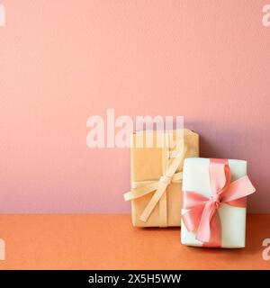 Gift boxes on orange table. pink wall background with copy space Stock Photo