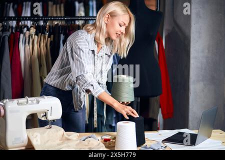 young woman preparing thred for sewing, making decision , close up side view photo, comparing thread Stock Photo