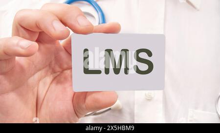 Word cloud concept. LMS - Learning Management System acronym the inscription on the business card is in the hands of a man in a white shirt Stock Photo