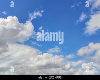 Mesmerizing cloudscape, with fluffy white cumulus clouds drifting across a vibrant blue sky Stock Photo