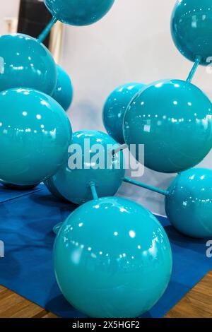 An exhibition of blue balls arranged in the shape of a crystal. The arrangement of the beads resembles a DNA double helix, with each bead representing Stock Photo