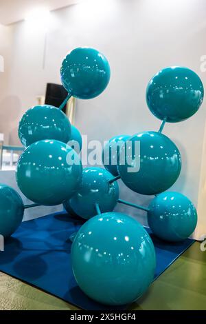 An exhibition of blue balls arranged in the shape of a crystal. The arrangement of the beads resembles a DNA double helix, with each bead representing Stock Photo
