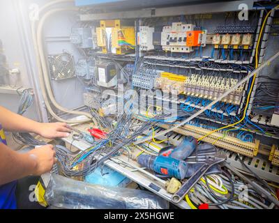 about the electrician doing recondition electrical systems there are magnetic, relay, wiring cable, breaker, overload protection, missy Stock Photo