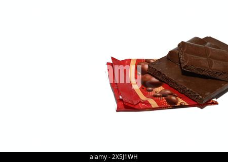 There is a chocolate bar on a package on a white background. Stock Photo