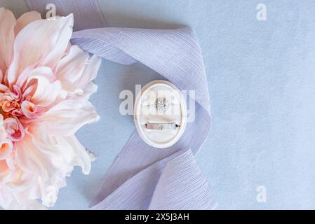 Diamond and platinum wedding rings styled with a pink dahlia on Stock Photo