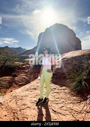 Woman standing between sunlight with mountains in the background Stock Photo