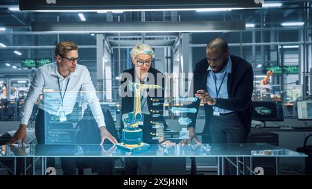 Industry 4.0 High-Tech Factory: Diverse Team of Robotics Engineers Working on Robot Arm Design, Using Augmented Reality Hologram to Manipulate 3D Model by Gestures. Engineering with Digital Technology Stock Photo