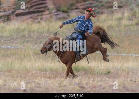 Asia, Mongolia, Bayan-Olgii Province. Altai Eagle Festival, Kazakh man shows off his riding skills. (Editorial Use Only) Stock Photo