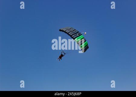 Skydivers Soar Under Vibrant Parachute Stock Photo