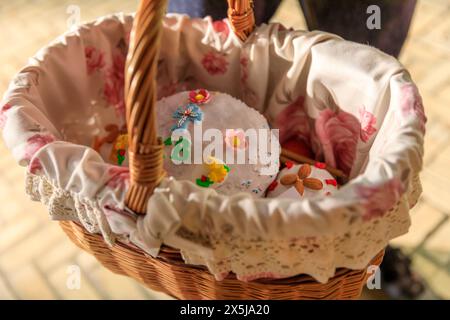 Ukraine, Kiev, Kyiv. Celebrating Easter with decorated small cakes and eggs in basket. Stock Photo