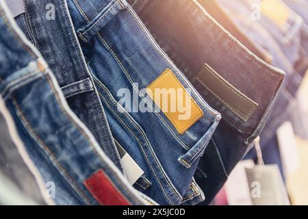 Many jeans hanging on arack. Row of pants denim jeans hanging in closet, concept of buy , sell , shopping and jeans fashion Stock Photo