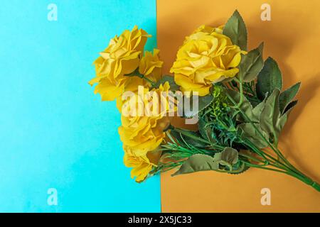 Bouquet of yellow roses on a blue and yellow background. top view. Stock Photo