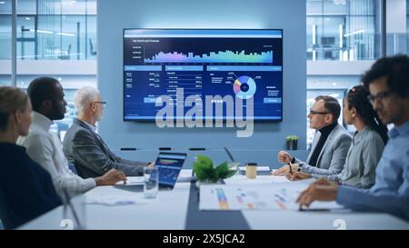 Office Conference Room Meeting: Multi-Ethnic Team of Businesspeople, Inverstorrs, IT Engineers Watch e-Commerce Social Media Software App Presentation. Animation of UI UX Working, Customer Support Stock Photo