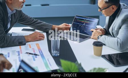 Multi-Ethnic Office Conference Room Businesspeople Meeting at Big Table. Diverse Team of Creative Entrepreneurs Talk, Find Solution. Specialists work in Digital e-Commerce Startup. Focus on Hands Stock Photo