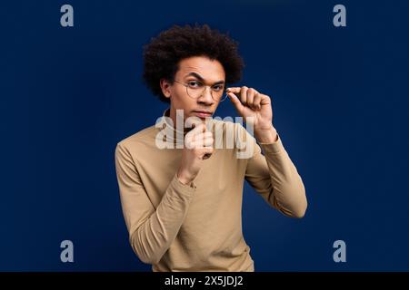 Photo portrait of nice young man look camera skeptical wear trendy beige outfit isolated on dark blue color background Stock Photo