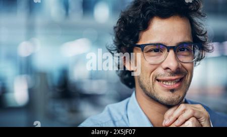 Portrait of Handsome Latin Man with Deep Brown Eyes, Wearing Stylish Piercing and Glasses Shows Warm, Kind, Charming Smile. Attractive Modern Gentleman Looks at the Camera. Close-up Bokeh Background Stock Photo