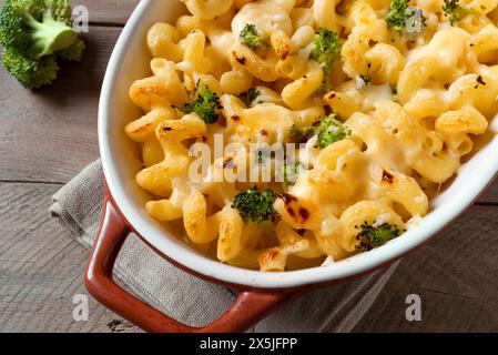 Mac and cheese with broccoli and parmesan oven baked close up. Traditional american meal, creamy macaroni pasta and cheese sauce casserole. Stock Photo