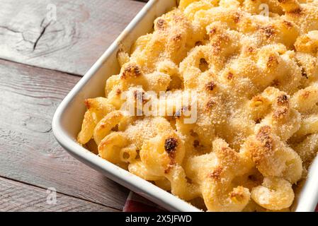 Traditional southern Mac and cheese with breadcrumbs close up. Homemade cheesy and creamy pasta casserole with meat for dinner. Stock Photo