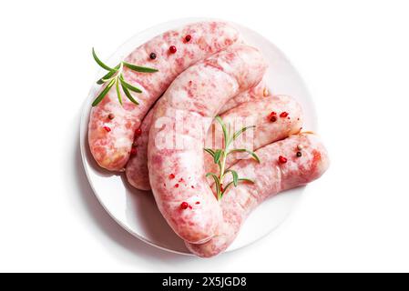 Raw sausages with spices and rosemary ready to grill isolated on white background. Cooking ingredients. Natural healthy food concept, top view. Stock Photo