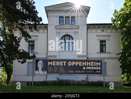 Apolda, Germany. 10th May, 2024. A banner in front of the Kunsthaus Apolda Avantgarde advertises the exhibition 'Meret Oppenheim & Friends'. The exhibition presents over 150 works by Meret Oppenheim (1913-1985) as well as other representatives of French Surrealism and her Swiss circle. It can be seen from May 12 to August 18. Credit: Martin Schutt/dpa/Alamy Live News Stock Photo