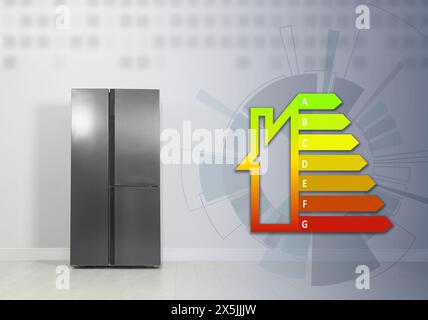 Energy efficiency rating label and refrigerator indoors Stock Photo