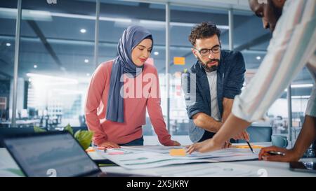 Multi-Ethnic Office Conference Room Meeting: Team of Three Creative Entrepreneurs Talk, Discuss Growth Strategy. Stylish Young Businesspeople work on Digital e-Commerce Startup. Stock Photo